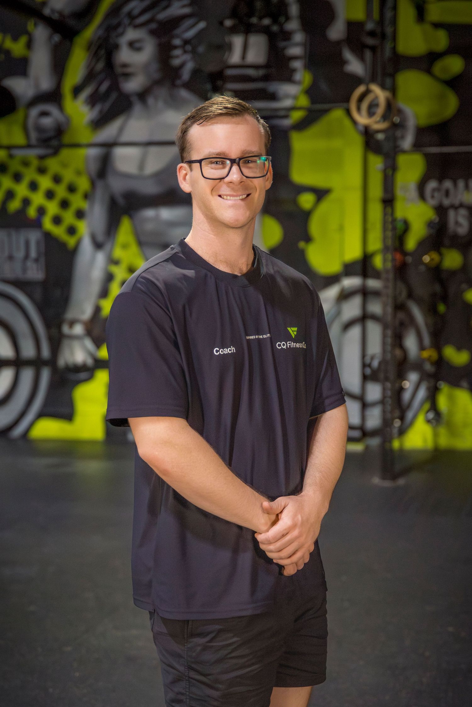 Gym coach headshots in front of gym mural at Rockhampton CrossFit location