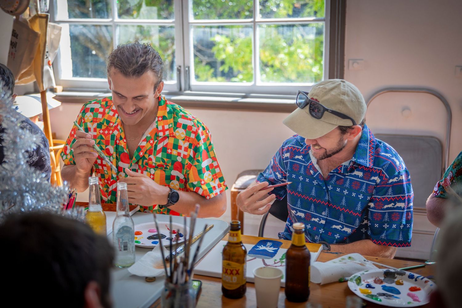 Guests sharing a laugh at a festive Christmas party in Rockhampton, wearing colourful themed outfits