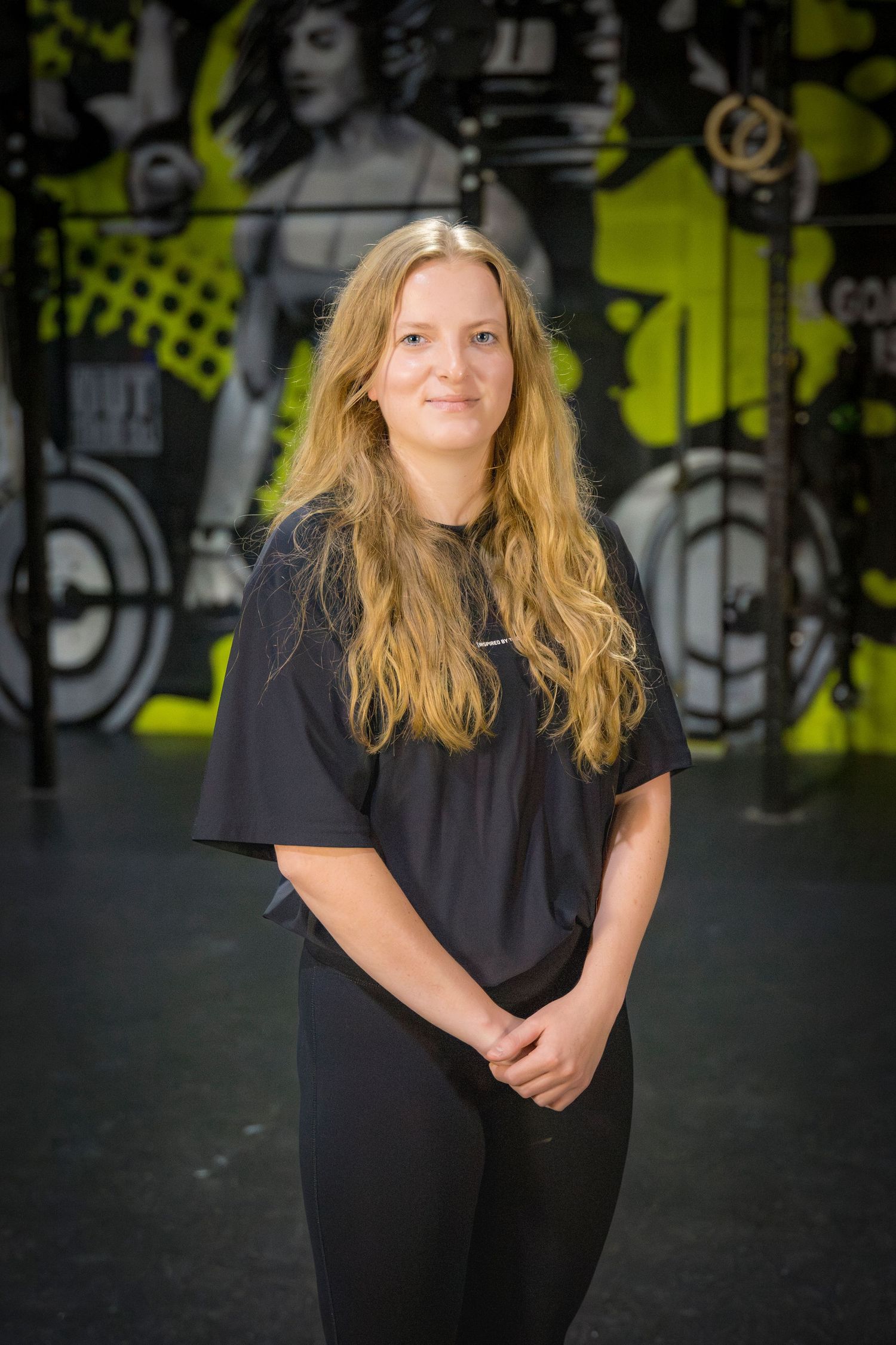Gym staff headshots in front of gym mural at Rockhampton CrossFit location