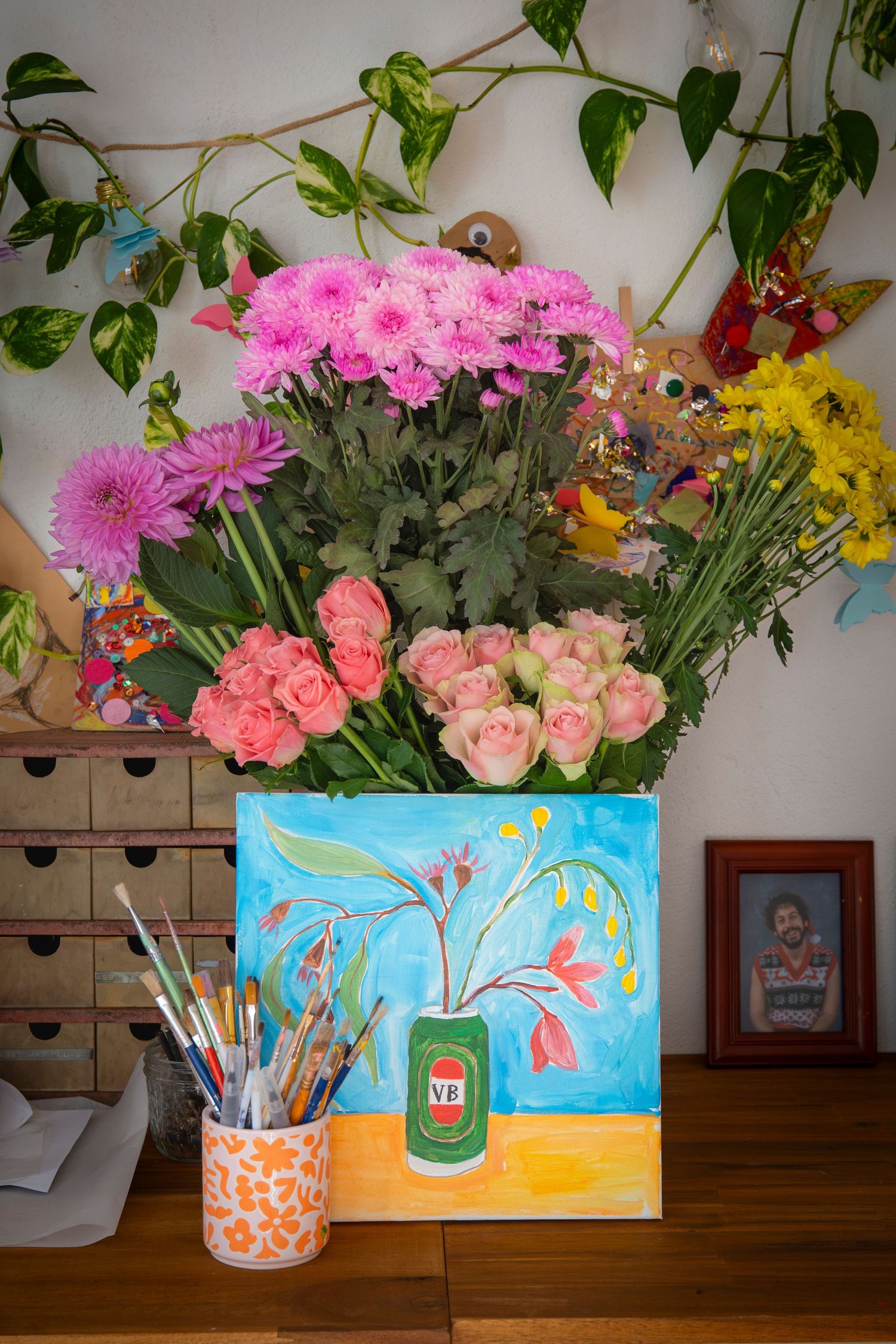 Styled bouquet of flowers in a bucket surrounded by wrapped gifts at a Rockhampton event
