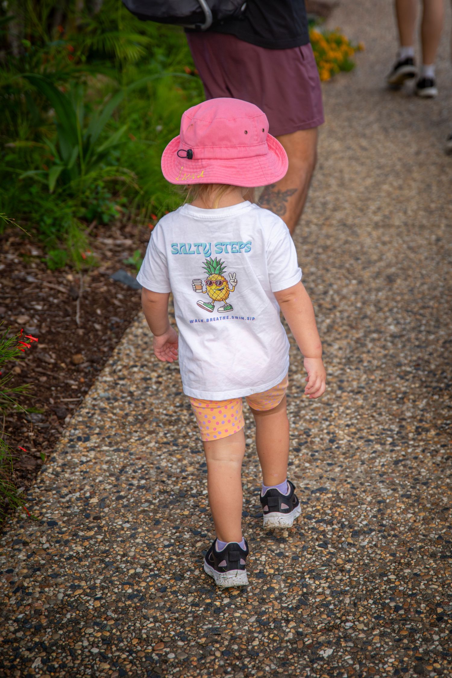 Child wearing salty steps shirt and pink hat