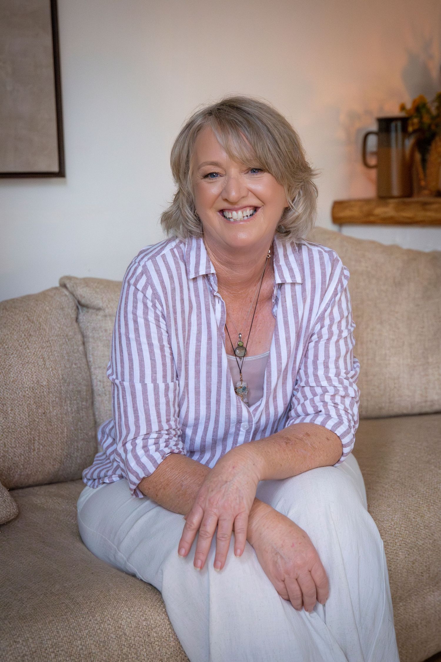 Professional headshot of a woman standing against a white backdrop in natural light, captured in a Rockhampton studio