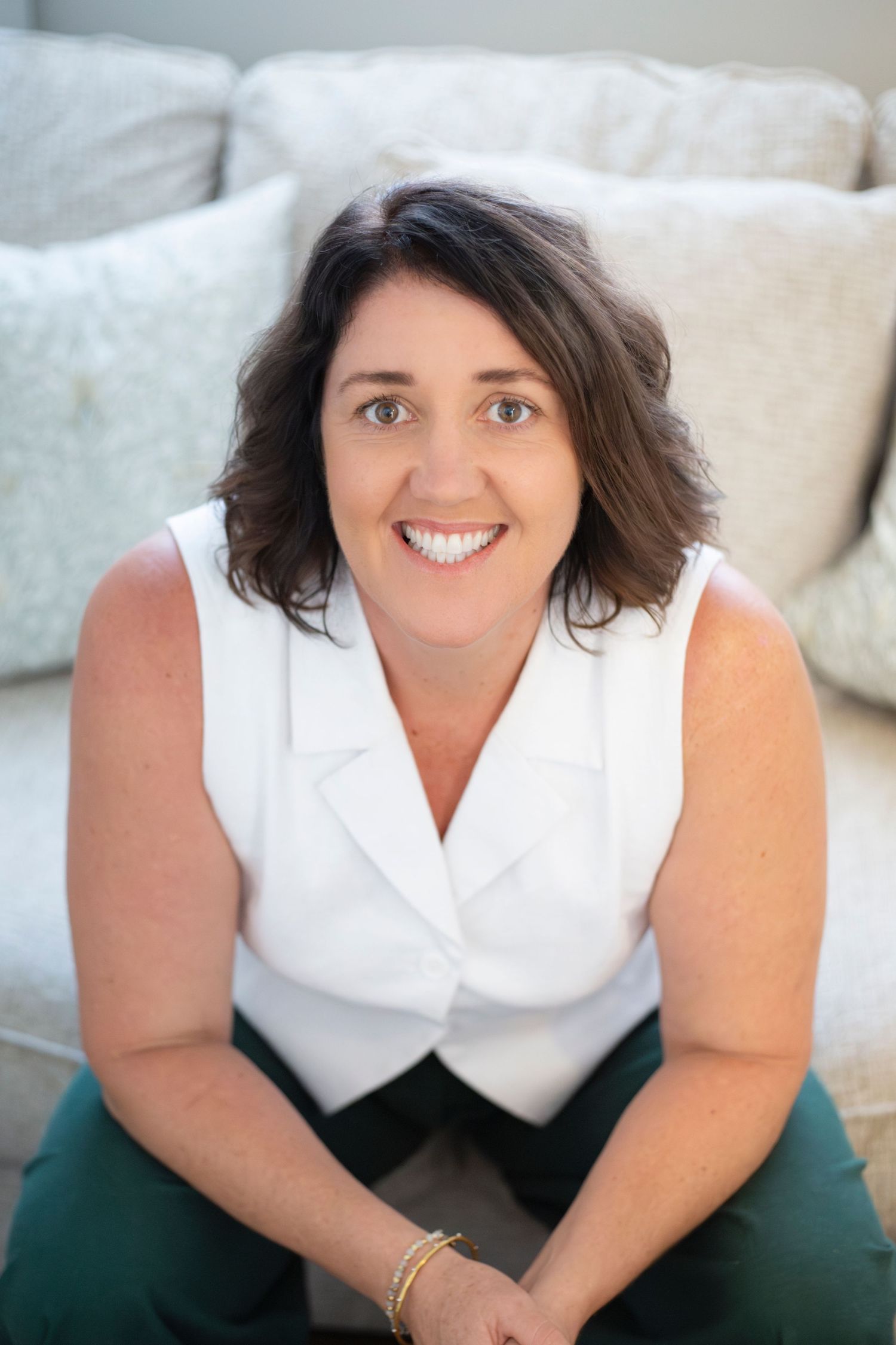 Branding portrait of a woman smiling while seated at her kitchen counter in Rockhampton, styled with a minimal lifestyle aesthetic