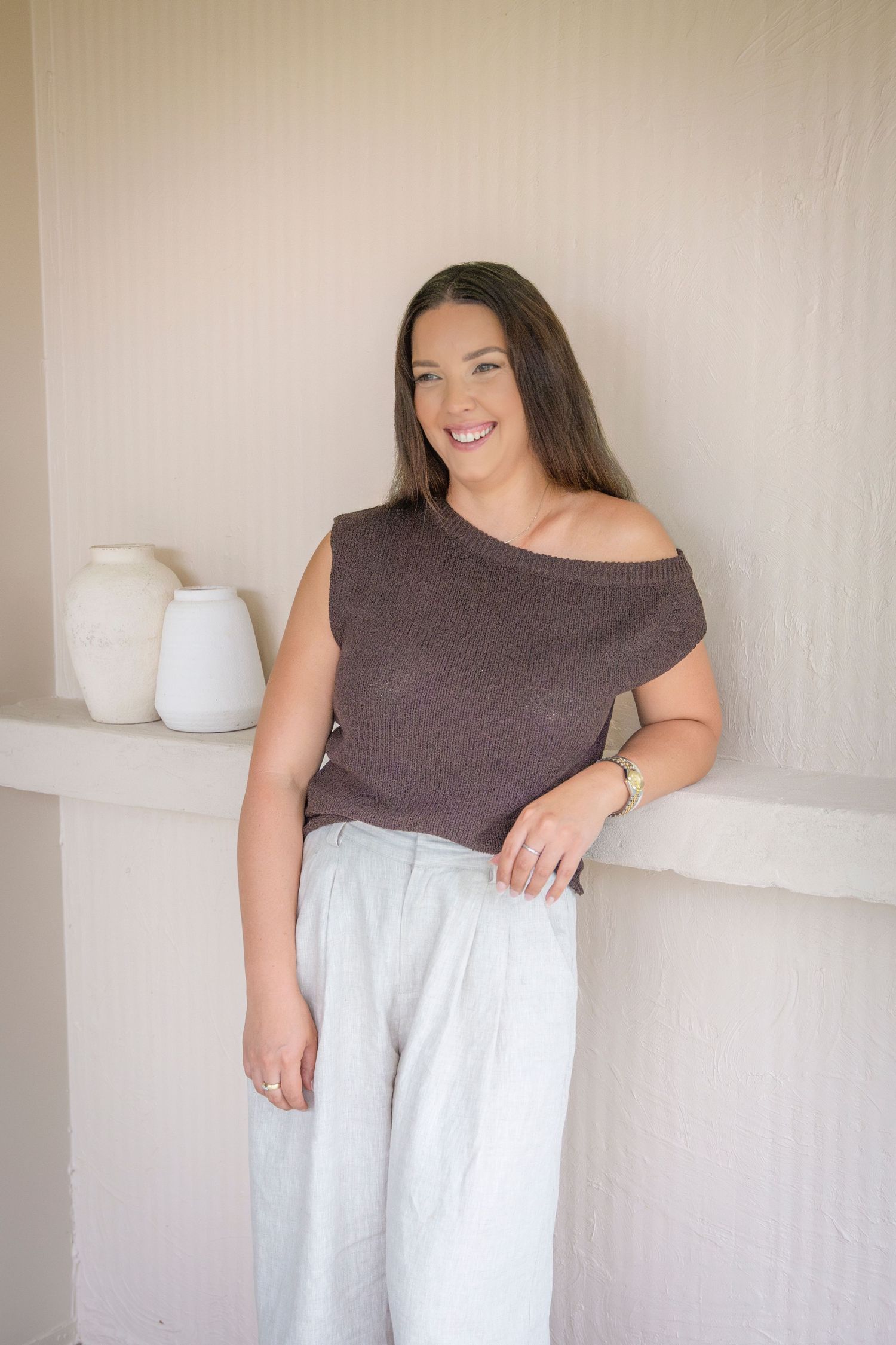Confident headshot of a woman seated in a minimalist Rockhampton studio, captured in soft, natural light