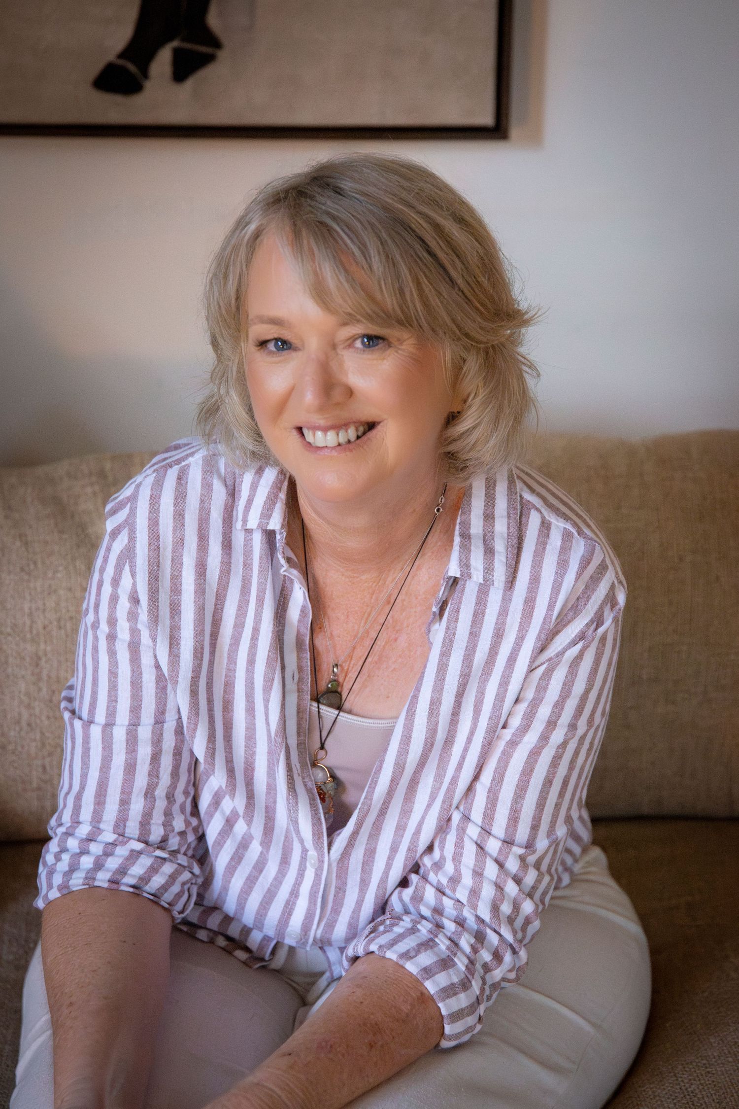 Professional modern headshot of a woman seated in a minimalist Rockhampton studio, relaxed confidence