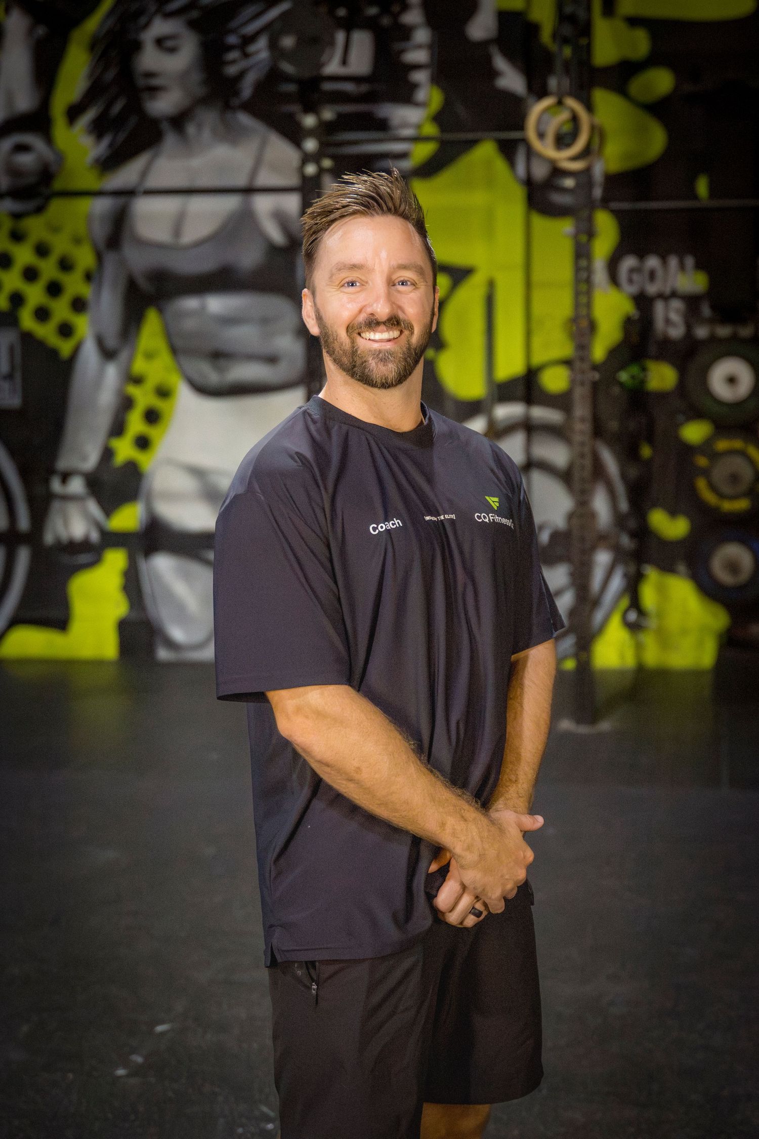 Gym coach headshots in front of gym mural at Rockhampton CrossFit location