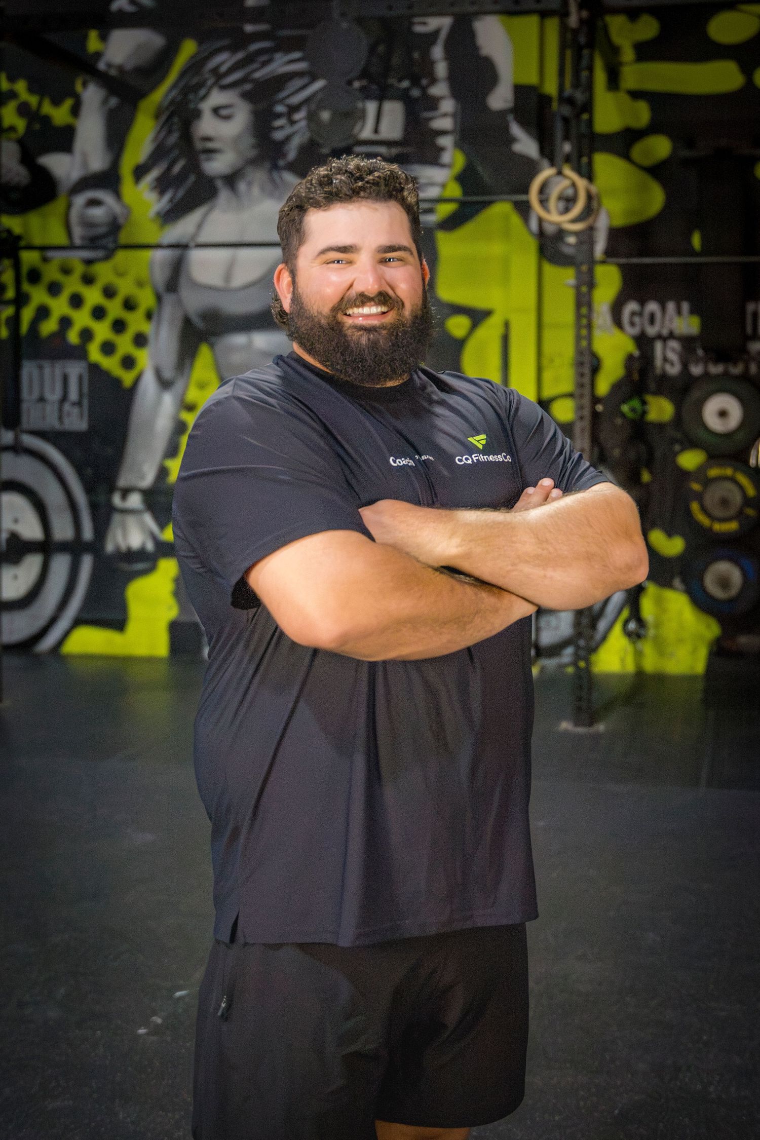 Gym coach headshots in front of gym mural at Rockhampton CrossFit location