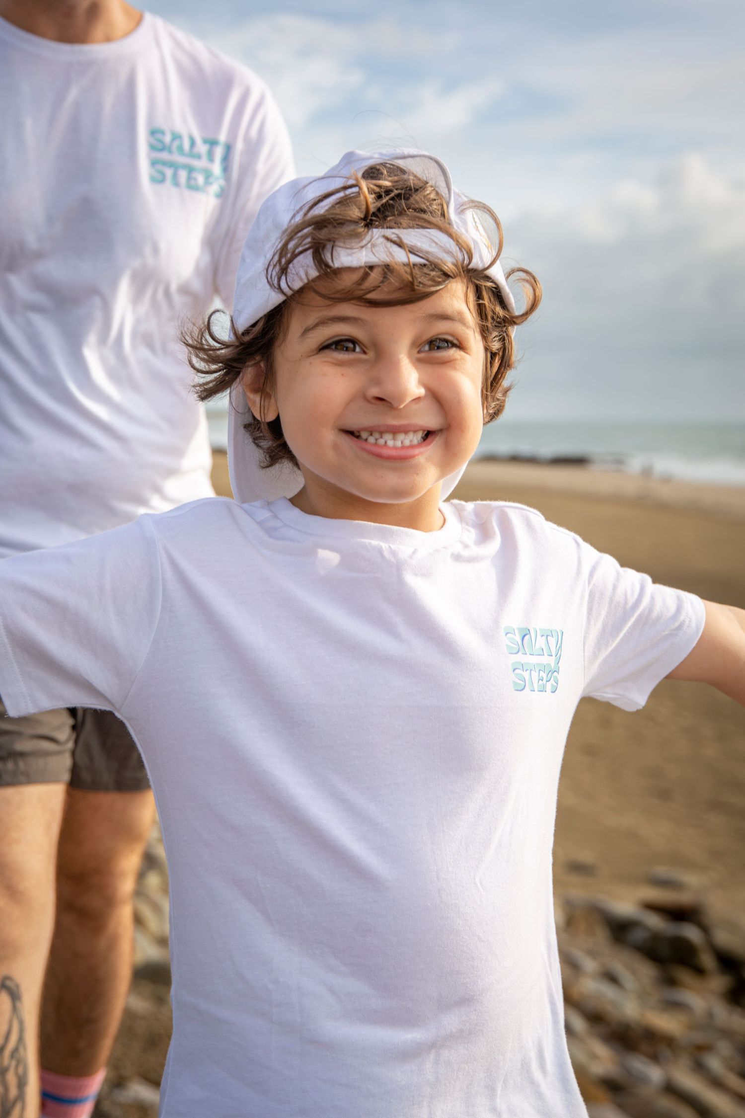 Smiling child wearing Salty Steps t-shirt and hat