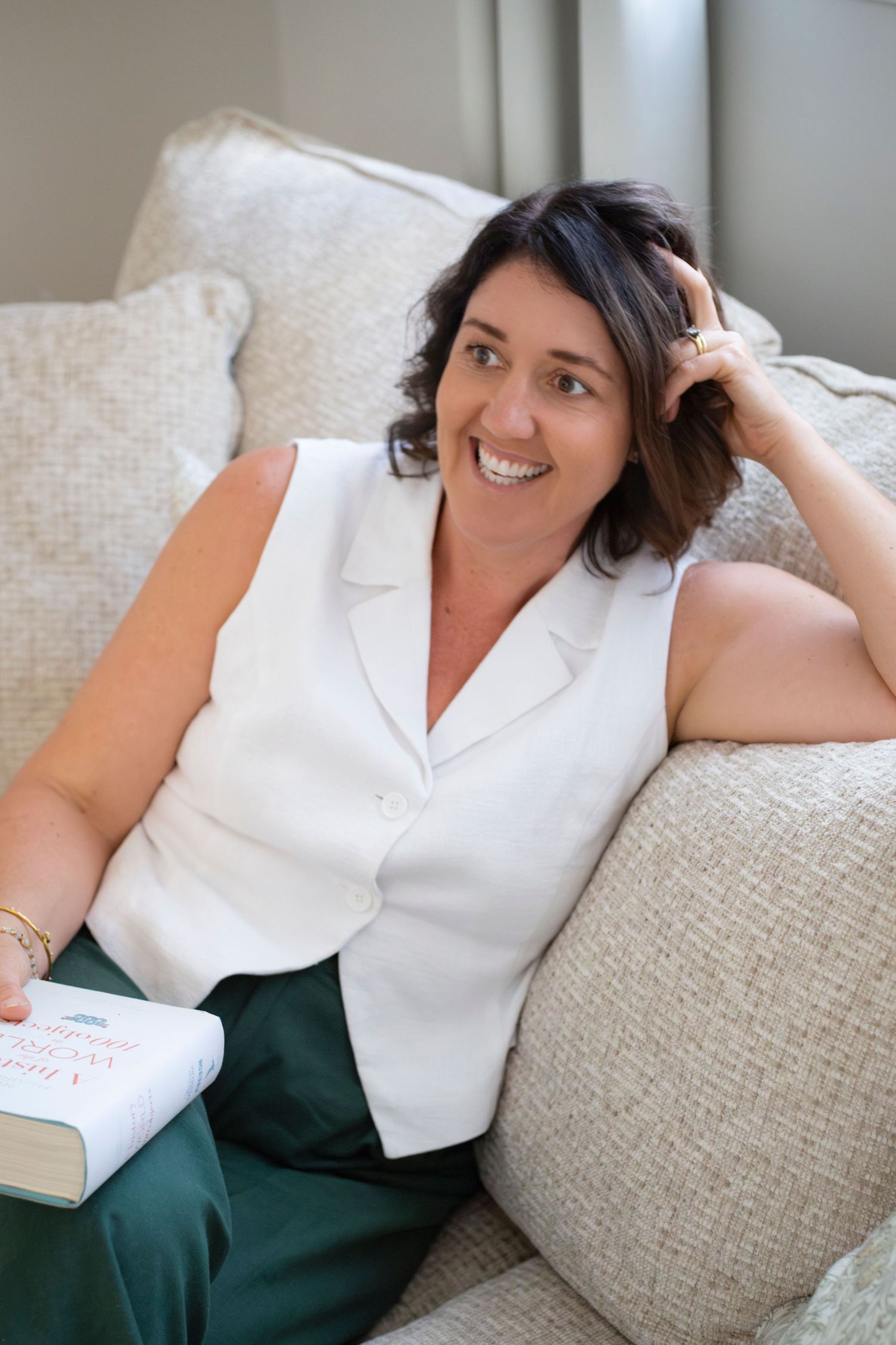 Branding portrait of a woman smiling while seated at her kitchen counter in Rockhampton, styled with a minimal lifestyle aesthetic