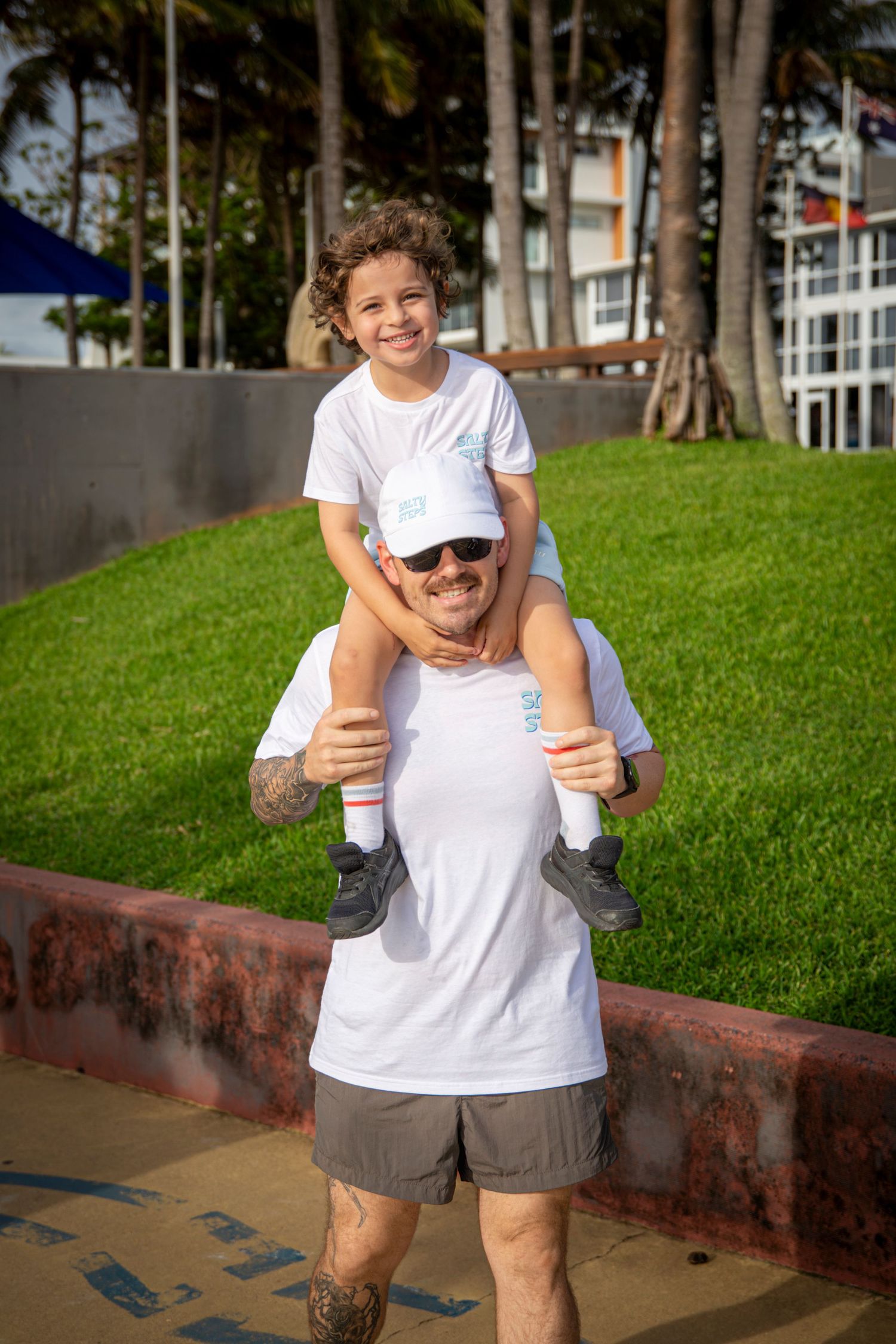 Child on Parents shoulders smiling at camera at event