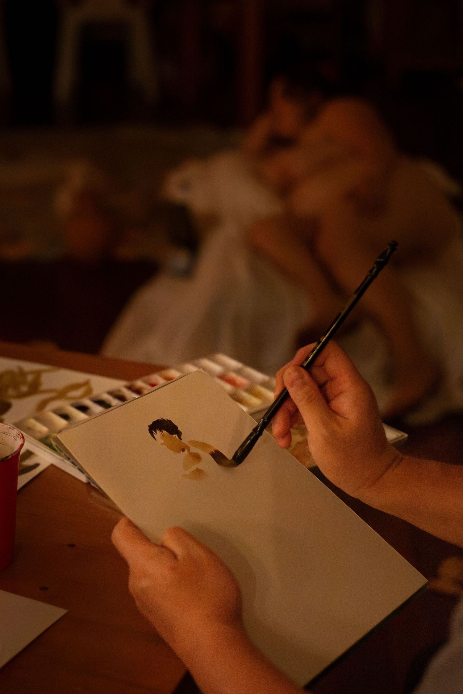 Artist painting by candlelight during an intimate creative event in Rockhampton