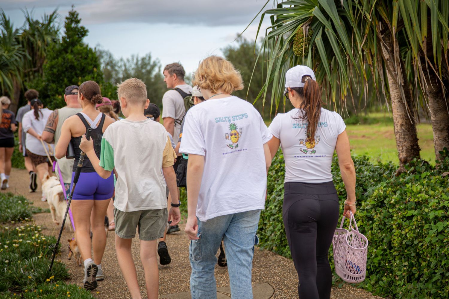Group walking along scenic coastal path in Yeppoon