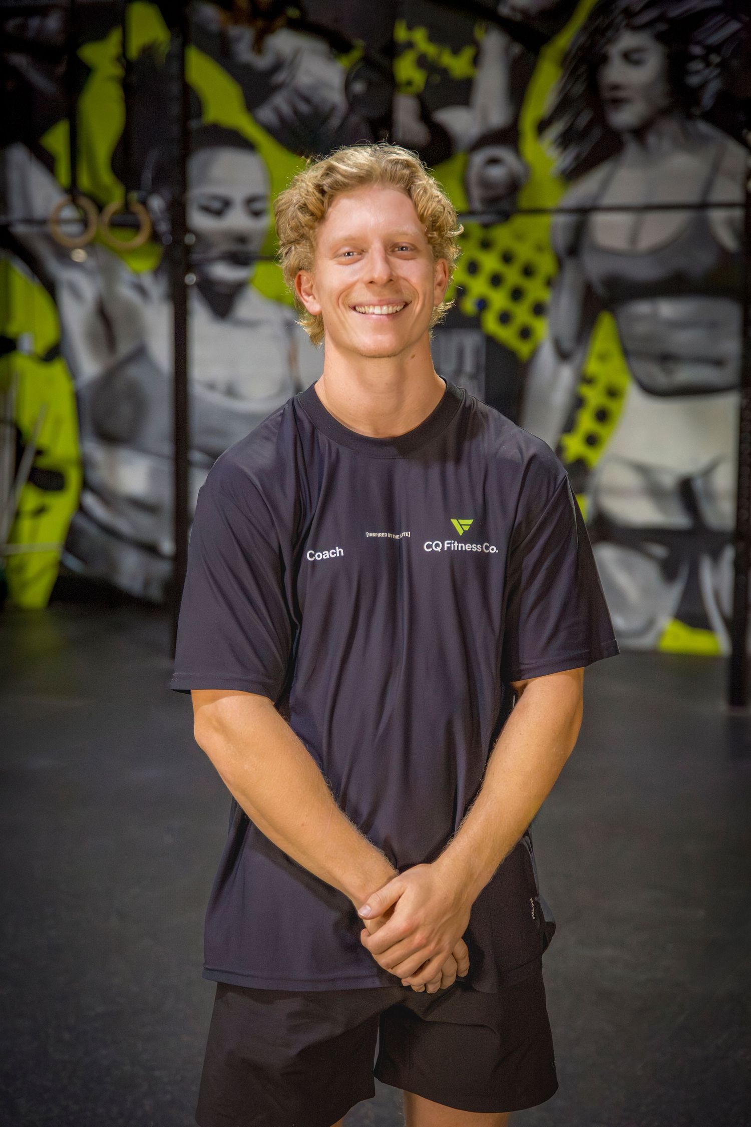 Gym coach headshots in front of gym mural at Rockhampton CrossFit location