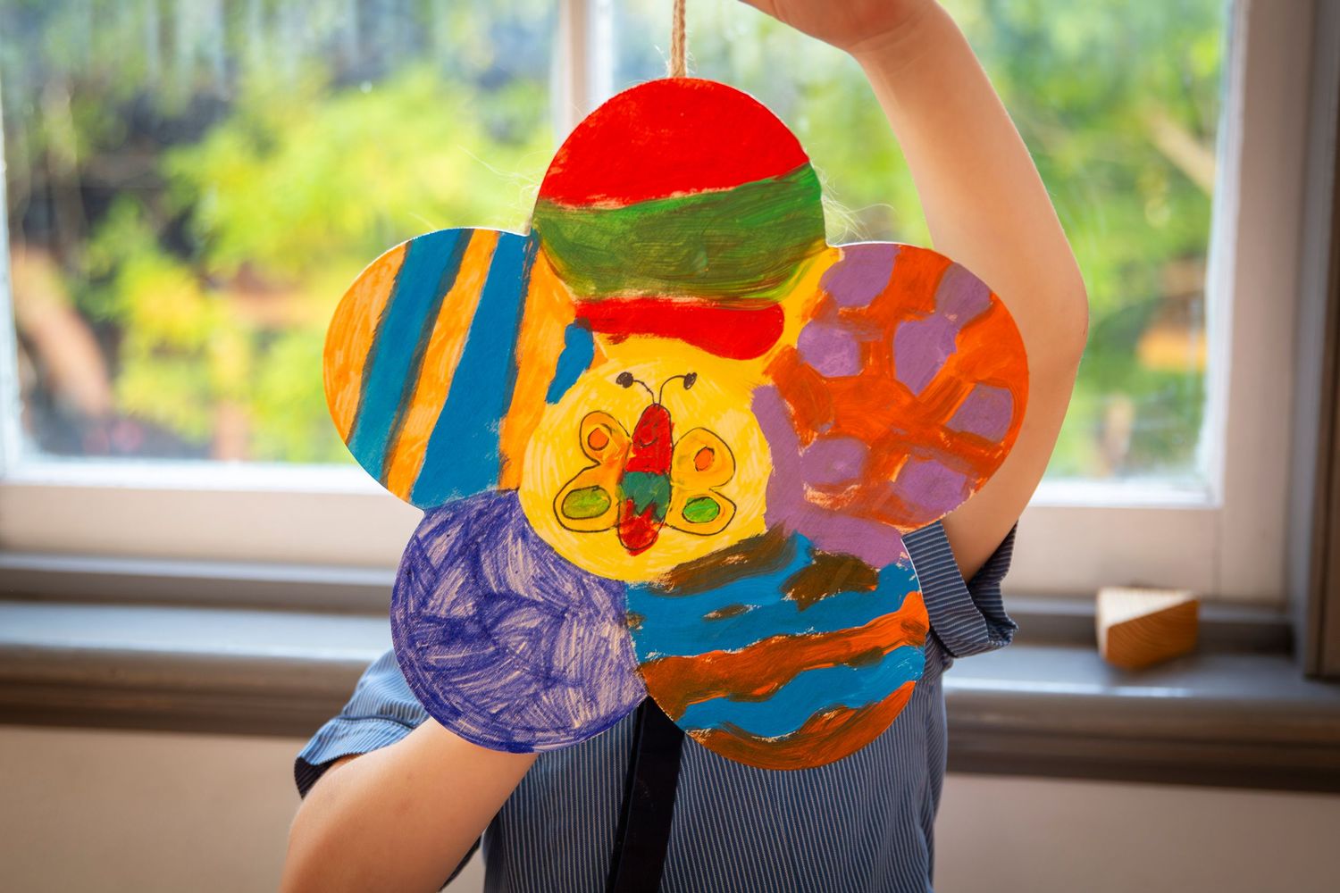 Child holding up their art work at class in Rockhampton