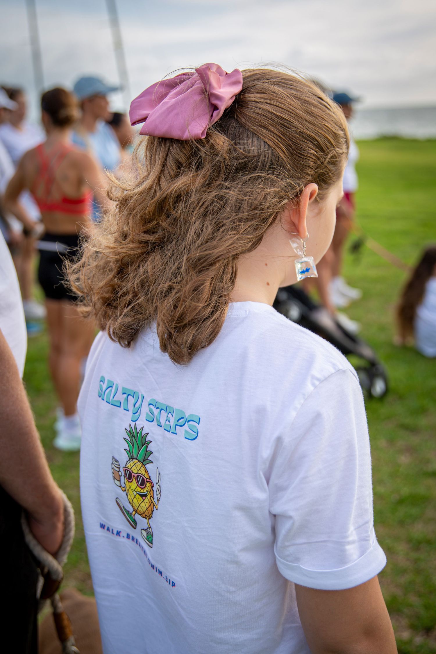 Girl with a bow in her hair wearing salty steps shirt at community walking event in Yeppoon