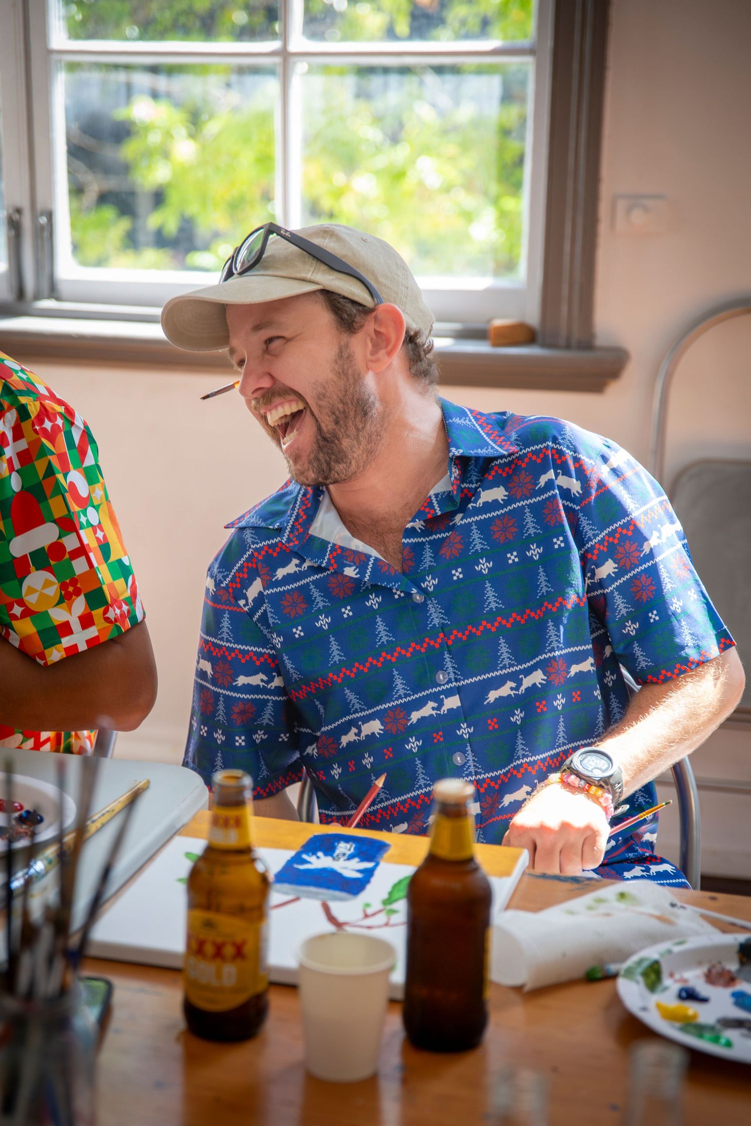 Guests sharing a laugh at a festive Christmas party in Rockhampton, wearing colourful themed outfits