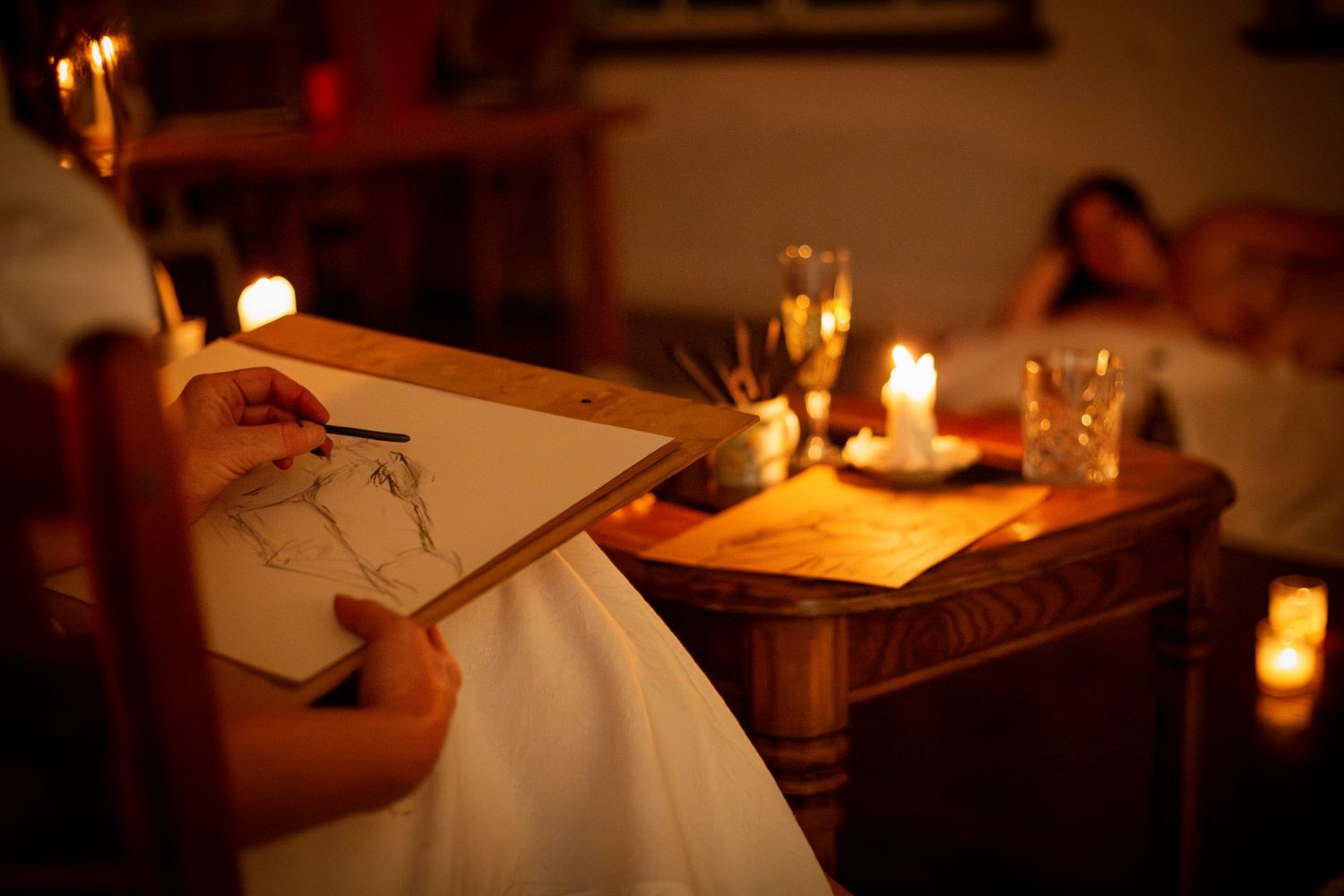 Close-up of an artist sketching on a clipboard under warm event lighting, Rockhampton event coverage