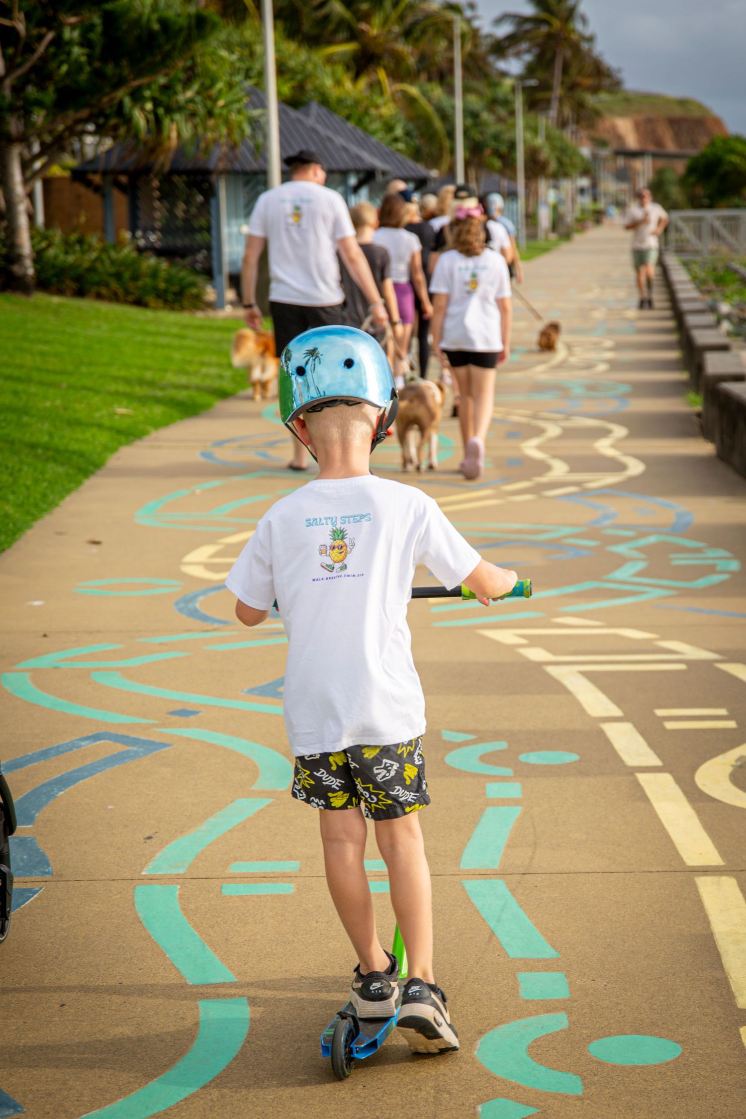 Child riding scooters wearing salty steps shirt in Yeppoon