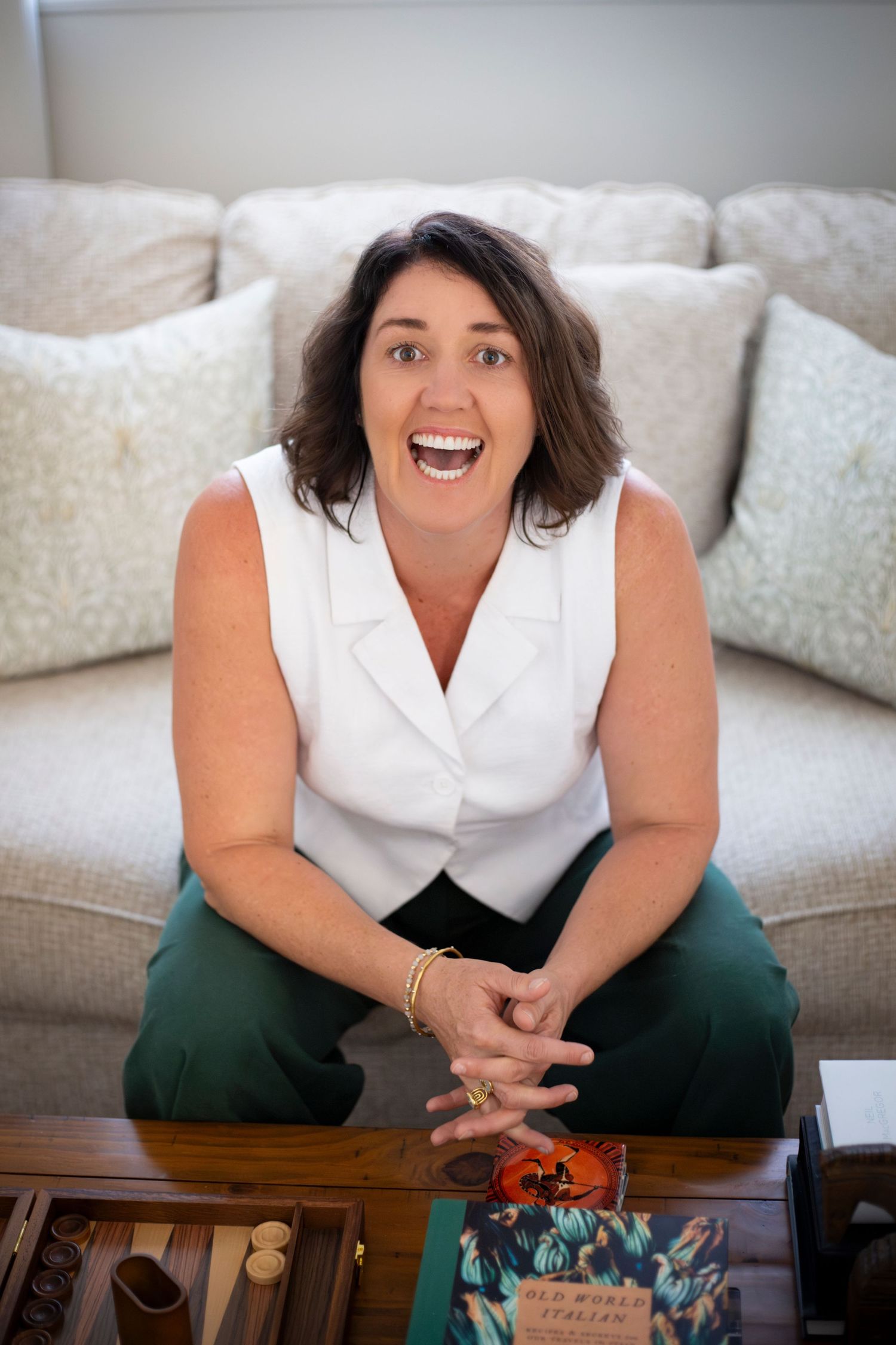 Branding portrait of a woman smiling while seated at her kitchen counter in Rockhampton, styled with a minimal lifestyle aesthetic