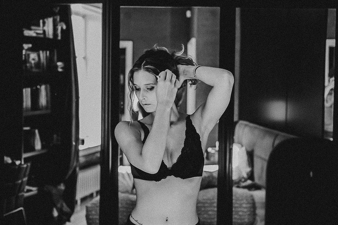 Woman in black athletic wear performs tricep exercises with dumbbells during a workout session.