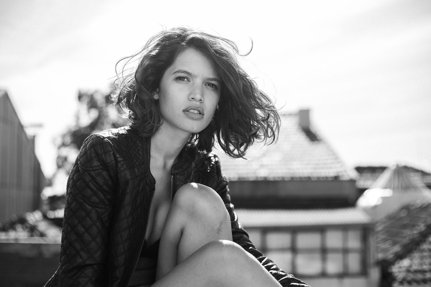 A dramatic black and white fashion photo series showing dynamic poses and flowing hair against urban backdrops.