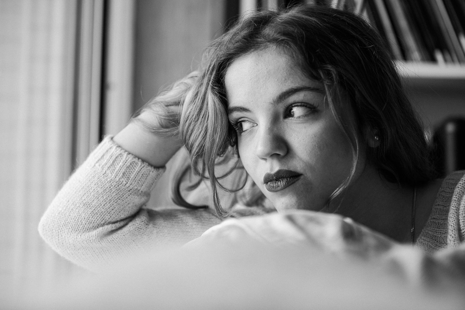 A series of black and white portraits showing various candid expressions and poses in a natural light setting.