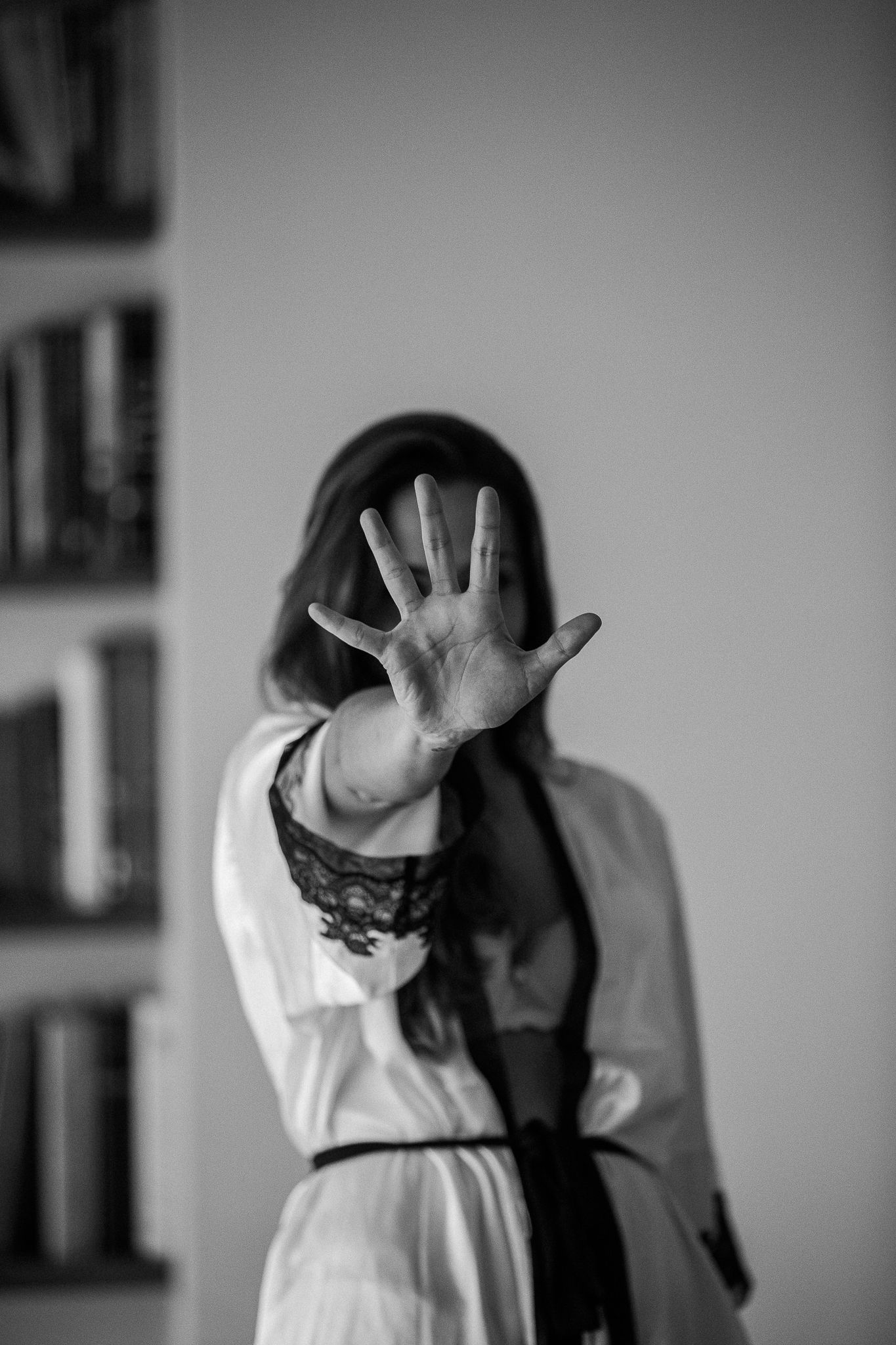 A sequence of black and white photos showing hands raised in defensive gestures against a blurred background.