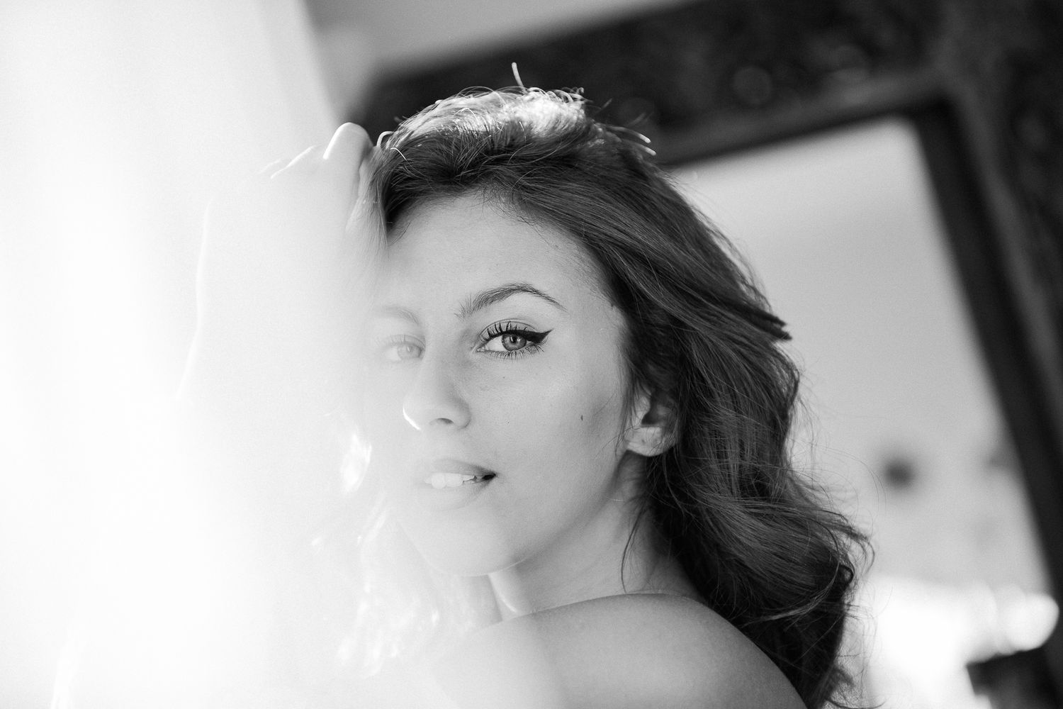 Black and white portrait showing a soft, ethereal side profile against a light background.