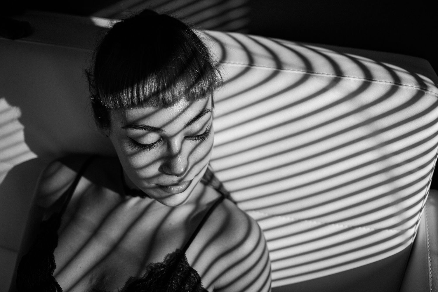Artistic black and white portrait with striped shadow patterns creating visual interest.