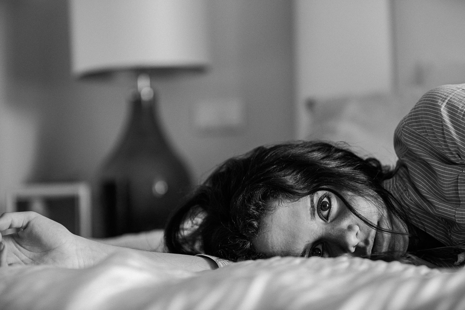 Intimate black and white series showing someone resting on bedding.