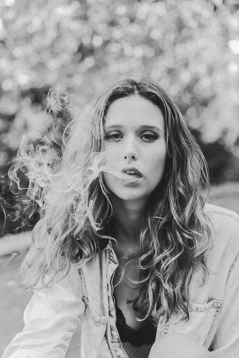 Series of monochrome close-up portraits featuring windswept curly hair and dramatic expressions.