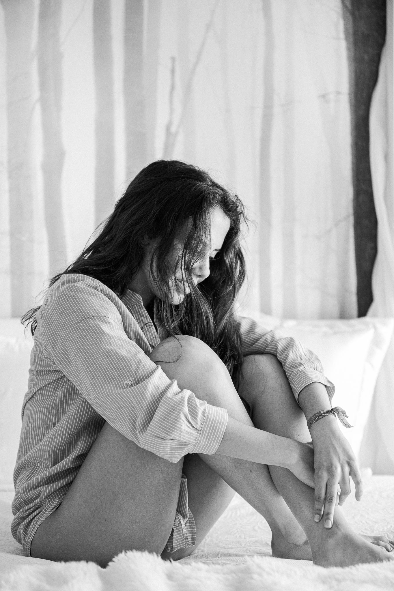 Intimate black and white portrait series on white bedding showing casual relaxed poses.
