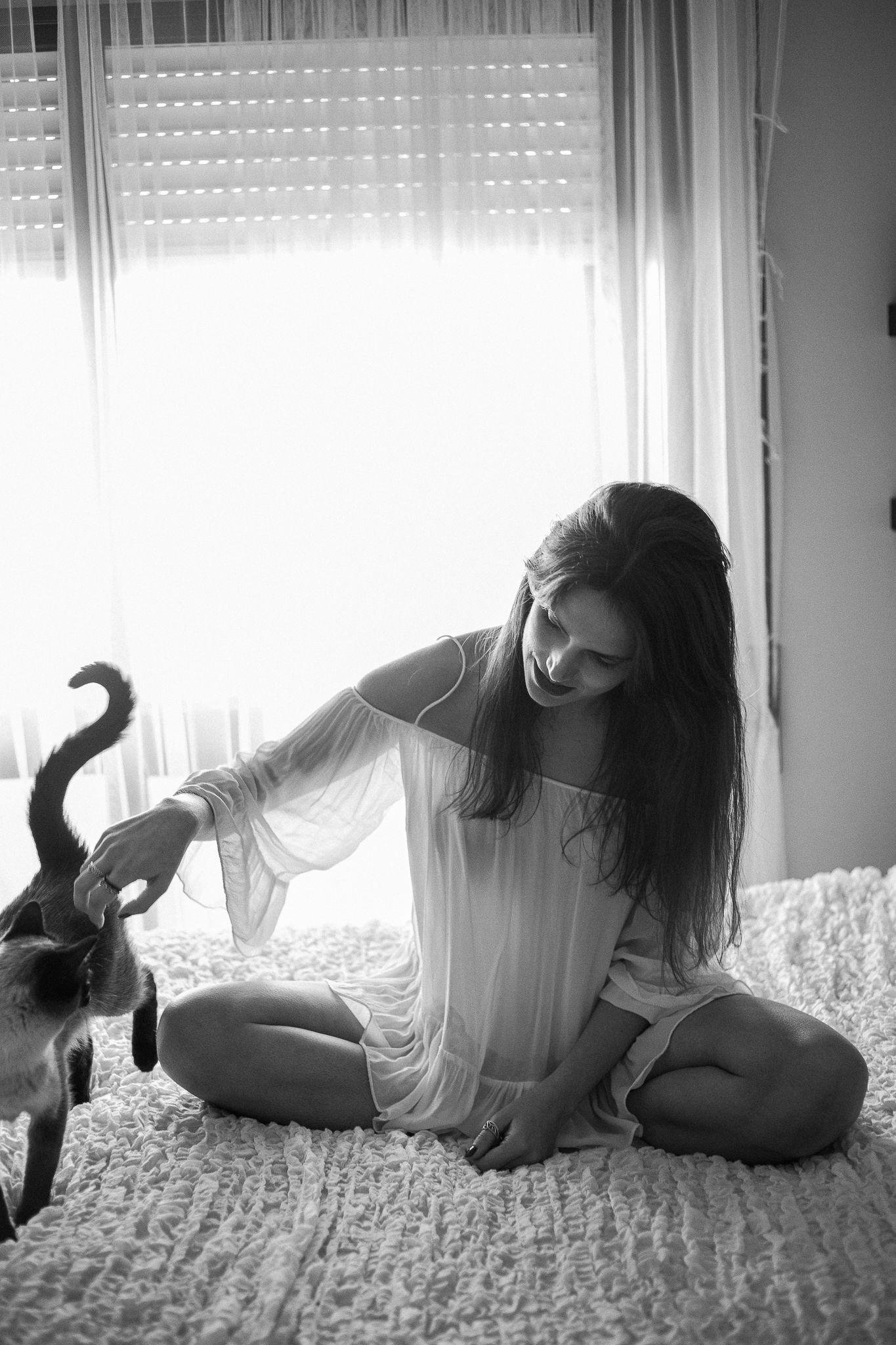 A black and white photo series shows a person lying on a carpet playing with a cat in four sequential poses.