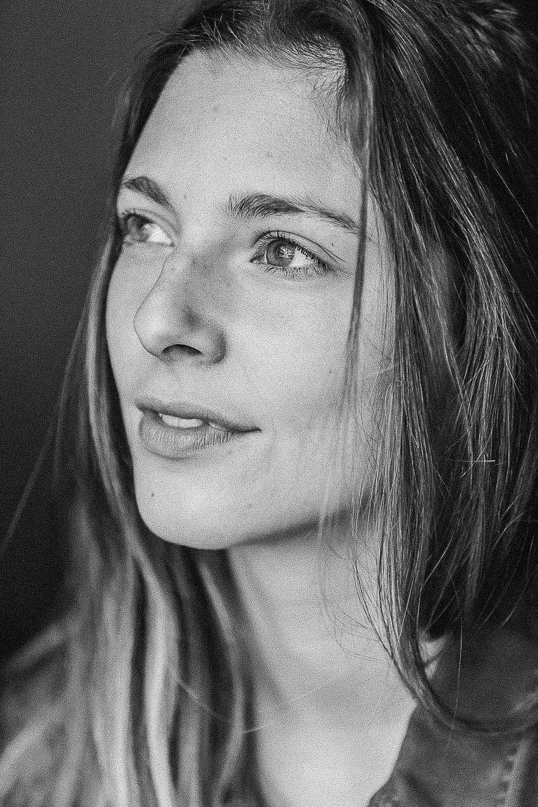 A black and white portrait series showing different angles and expressions in dramatic lighting.
