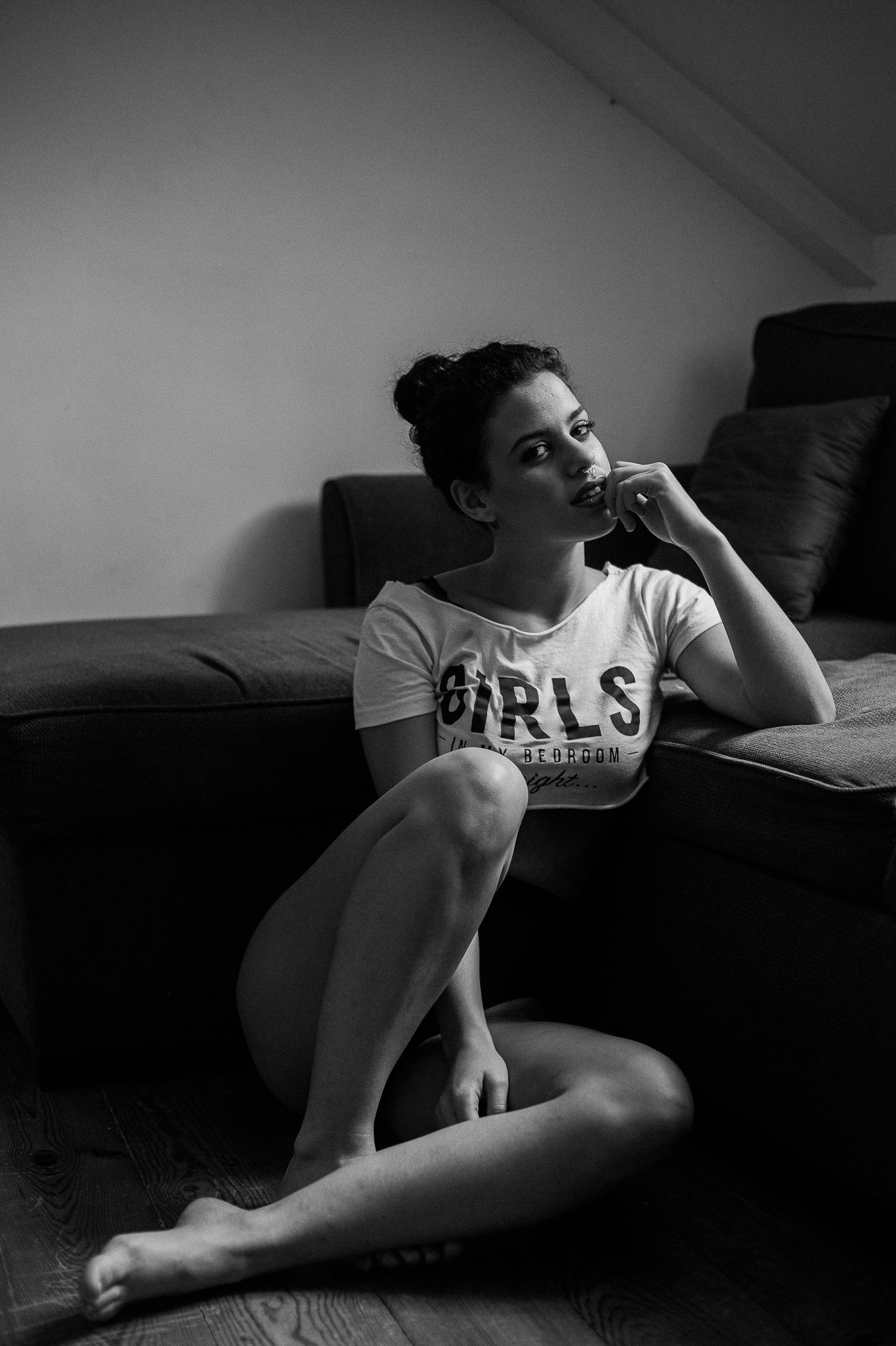 Black and white artistic photo series showing a person lounging on a dark couch in moody lighting.