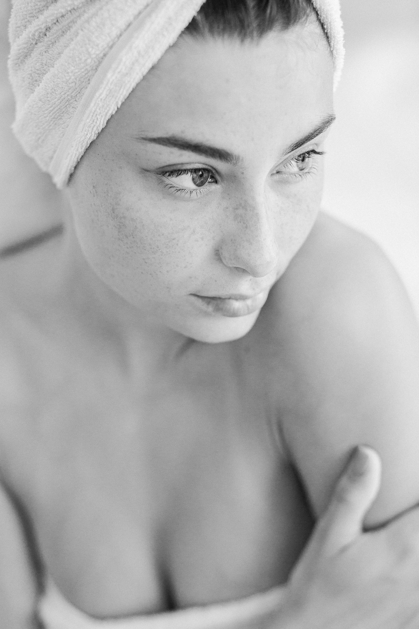 Intimate black and white portrait series with towel-wrapped hair in natural light.