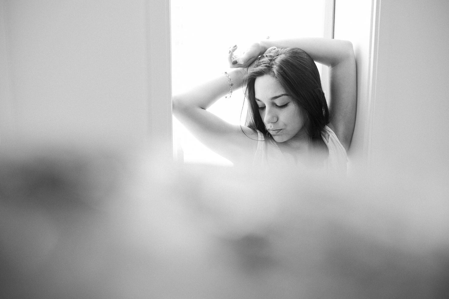 Black and white photo series showing intimate moments and details of a person in soft, moody lighting.