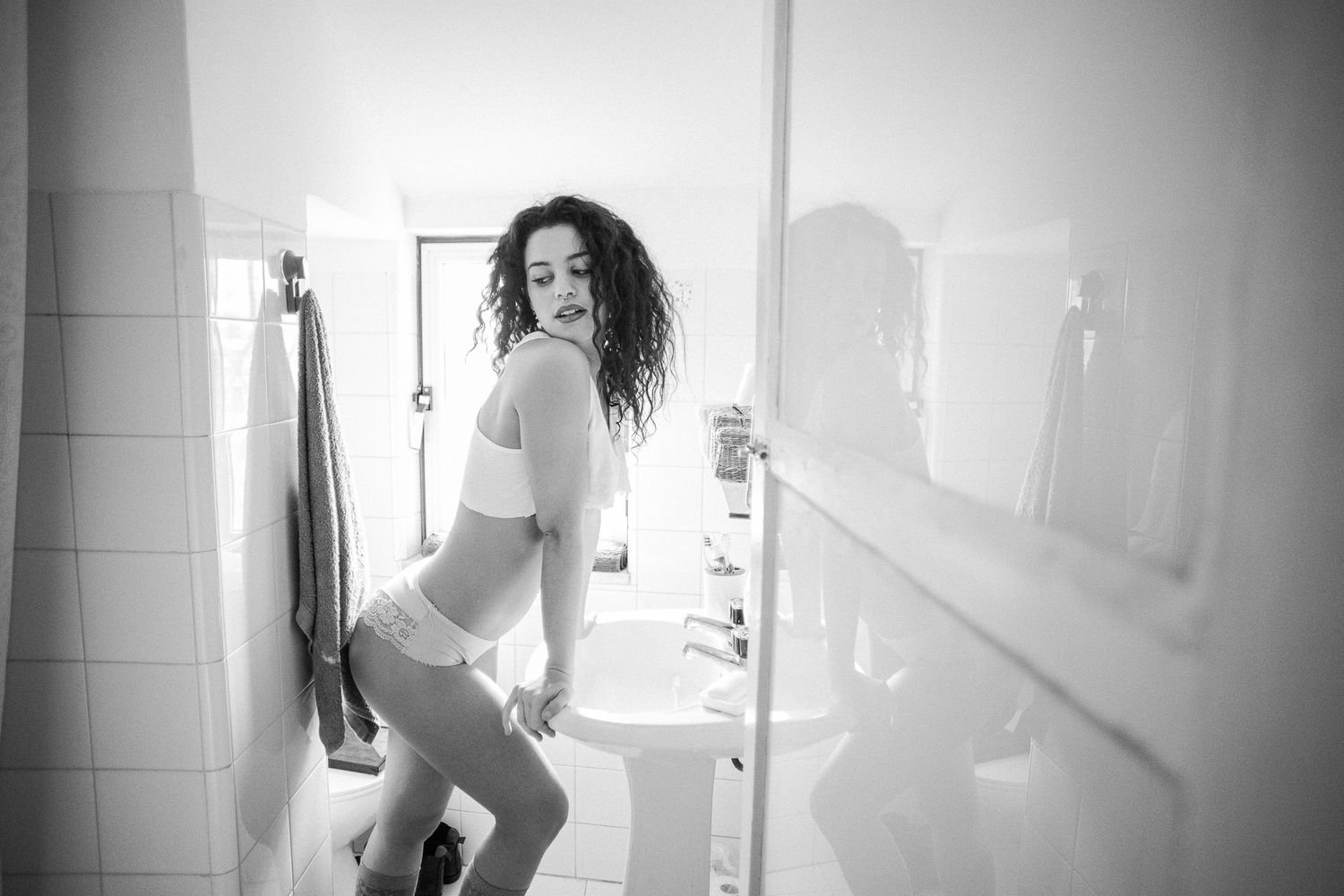 Black and white photo series capturing morning bathroom routine moments with natural window lighting.