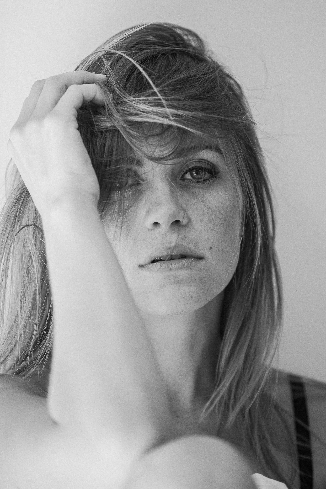 Artistic black and white portrait sequence showing hair movement and partial facial features in dramatic lighting.