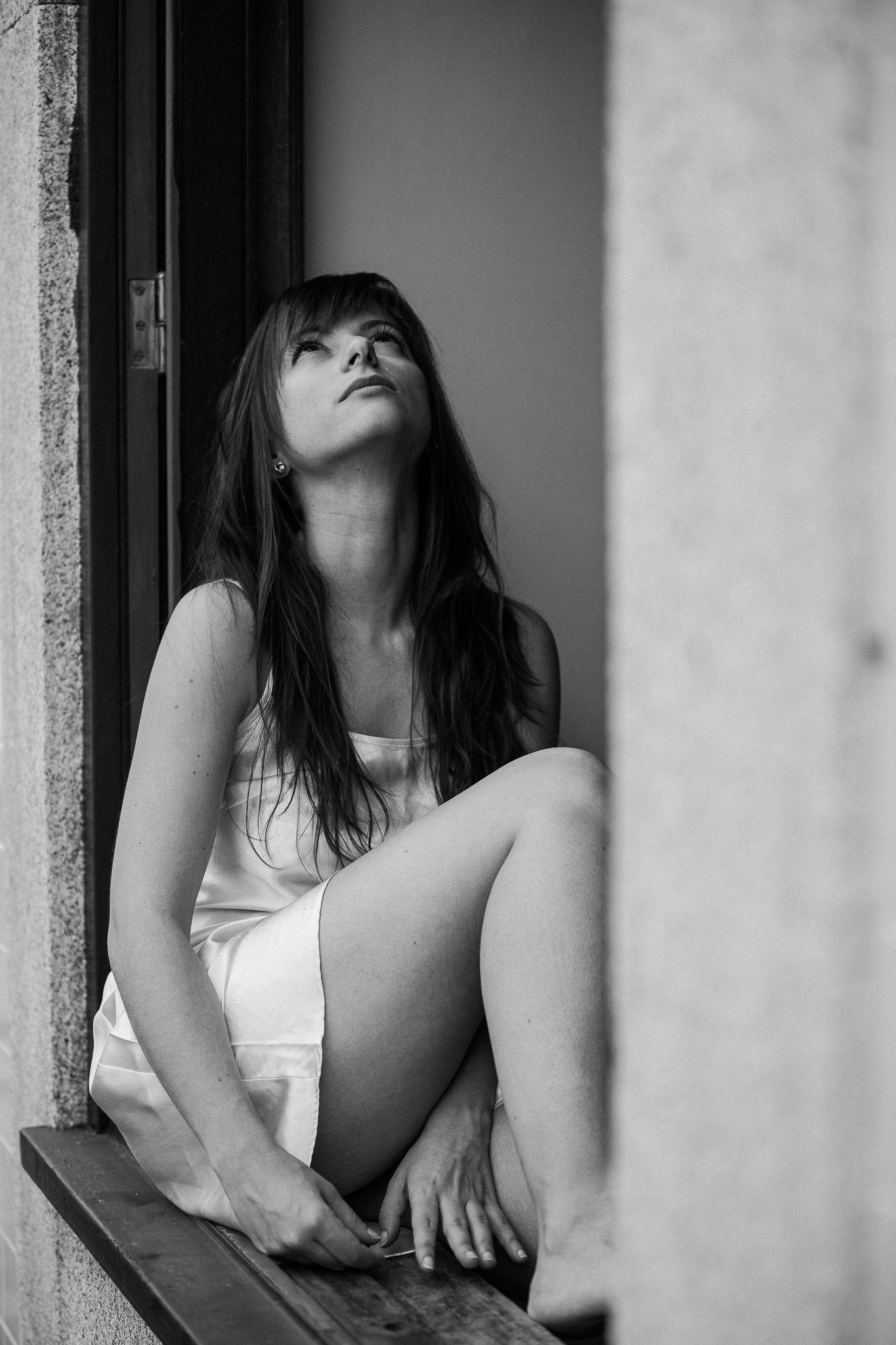 Artistic black and white photos captured through window frames with natural lighting.