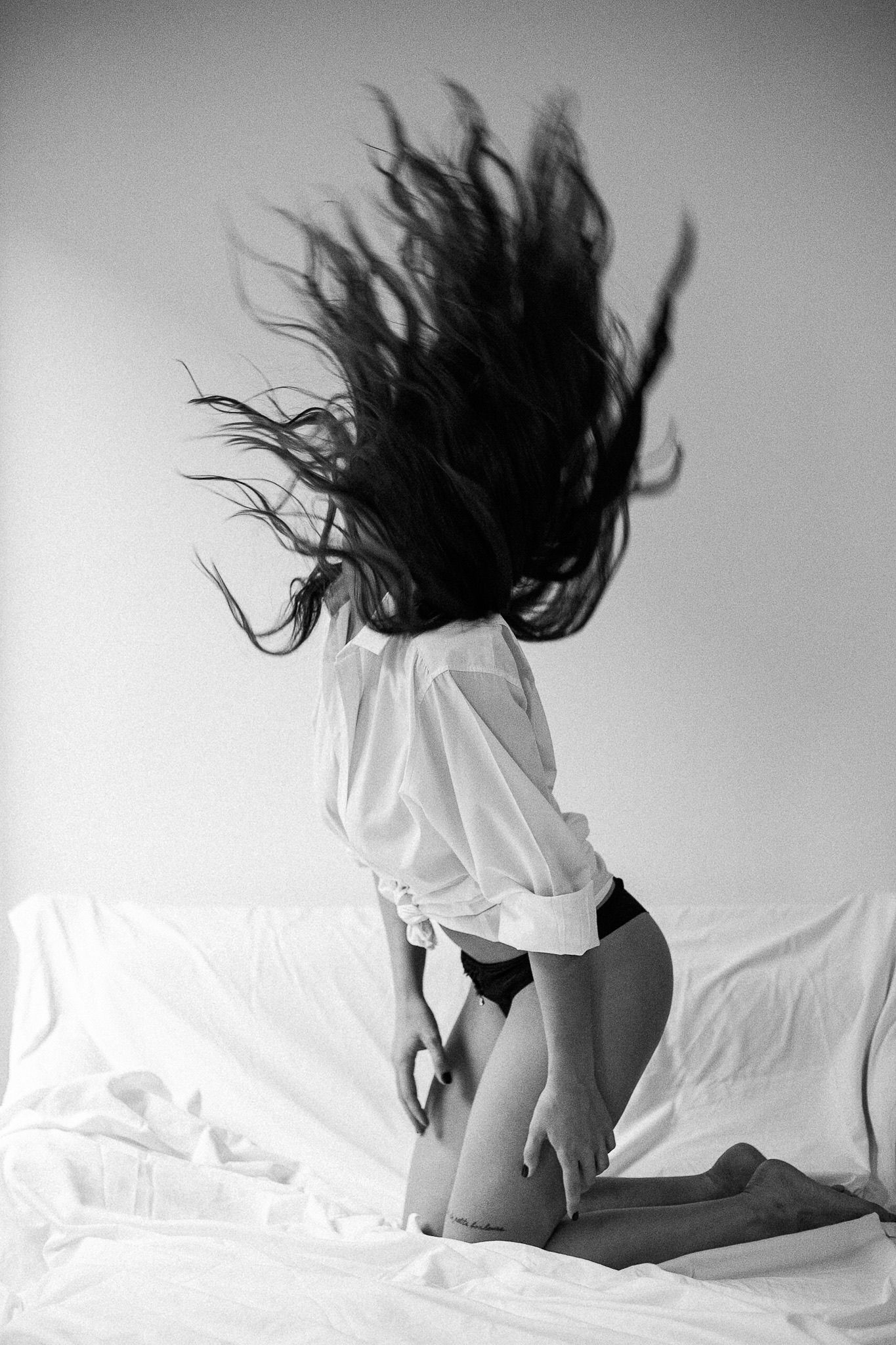 Dynamic black and white photo series capturing movement on white bedding.