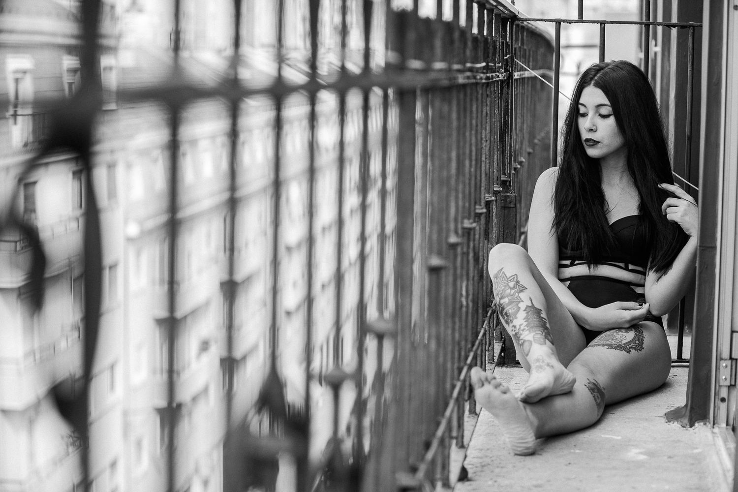 Monochrome photo series depicting a person posing gracefully near large windows in an industrial-style setting.