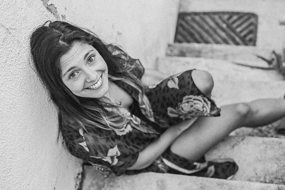 Black and white photo series of a person in casual wear posing playfully against a textured wall.