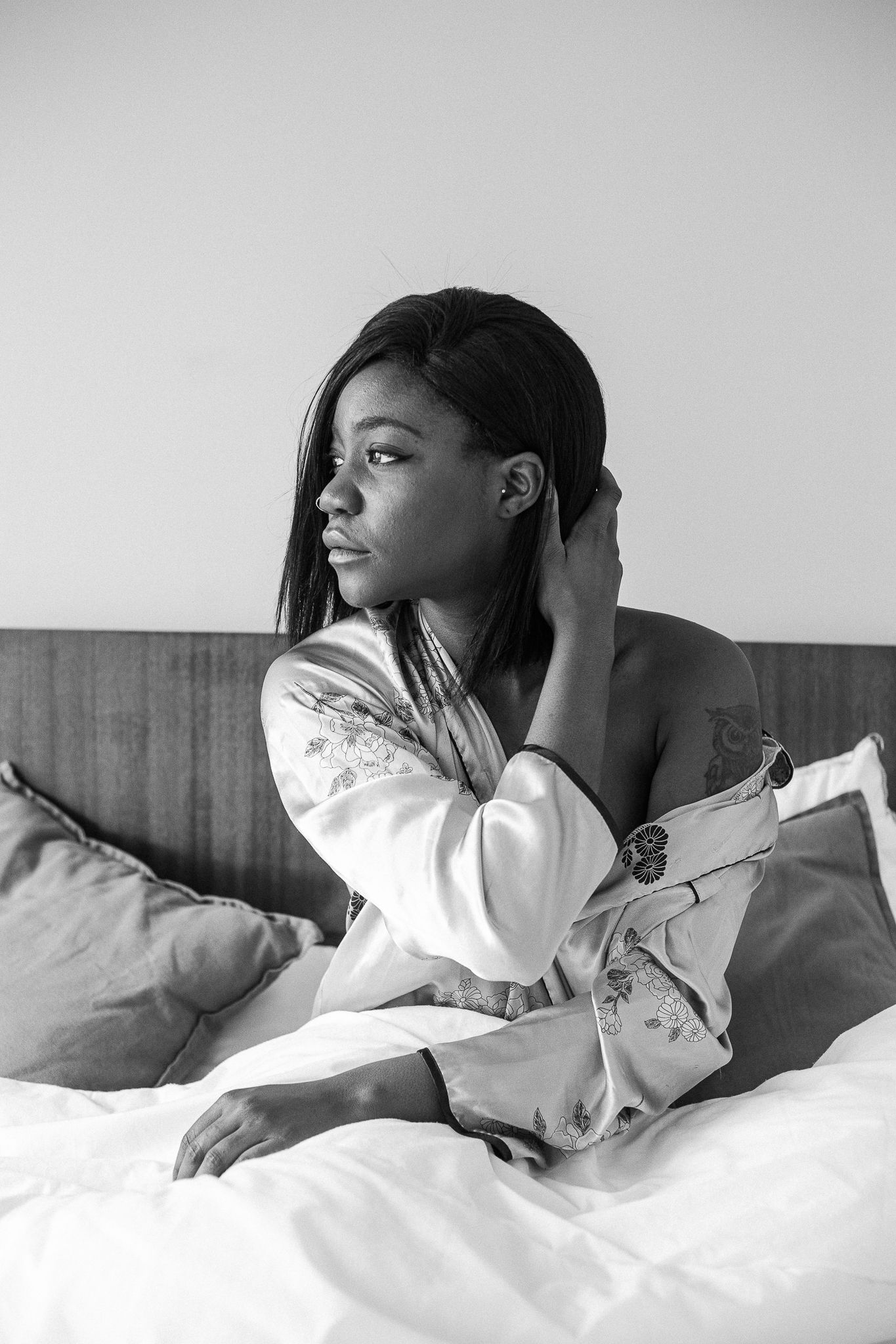 A sequence of black and white photos showing someone lying restlessly in bed with white sheets.
