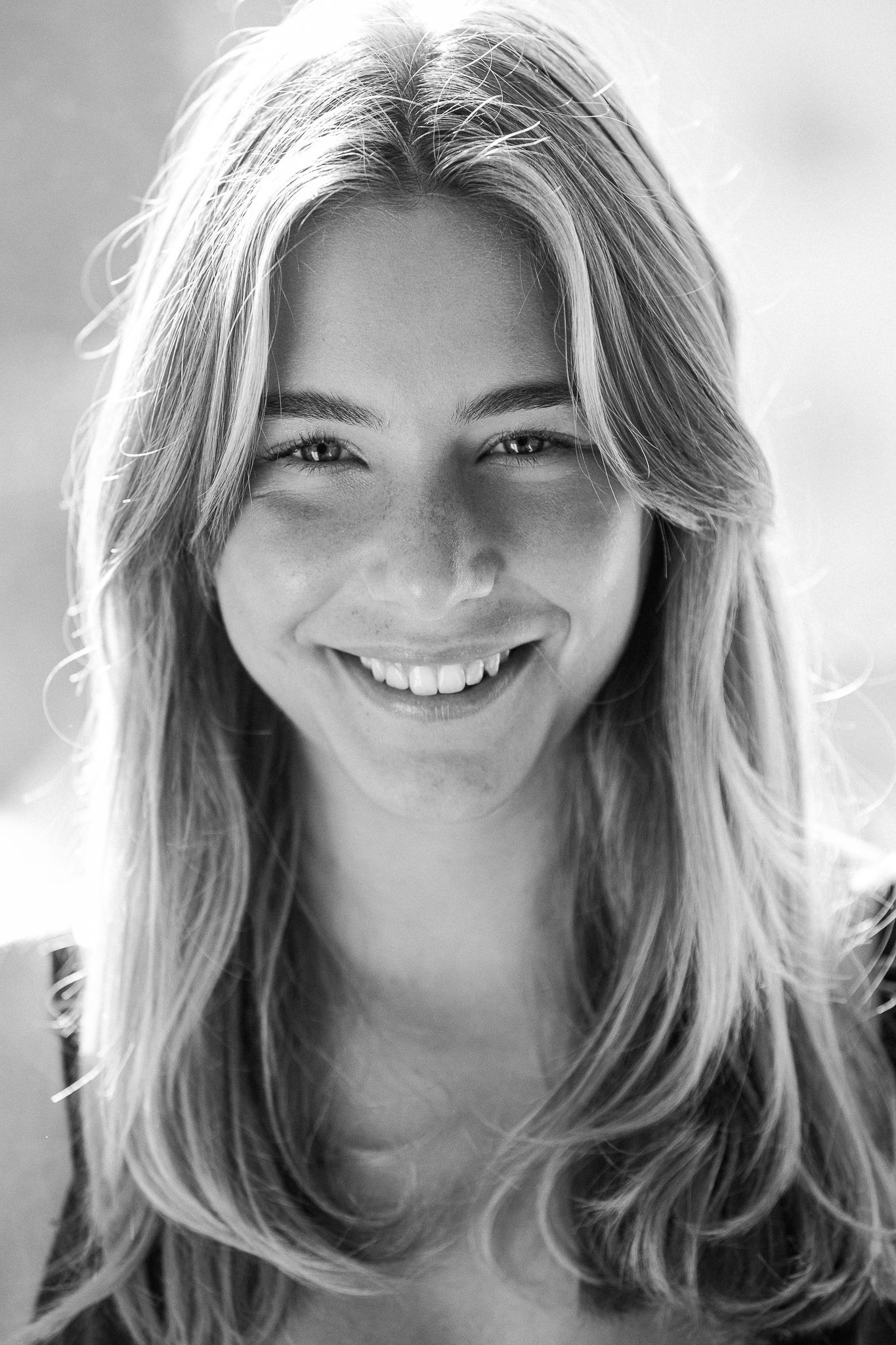 A series of five black and white portraits showing natural expressions and candid smiles.