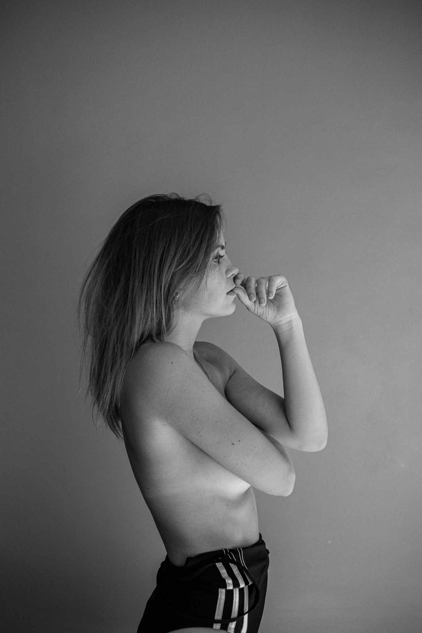 Black and white artistic portrait series showing a figure in shadow against a plain wall.