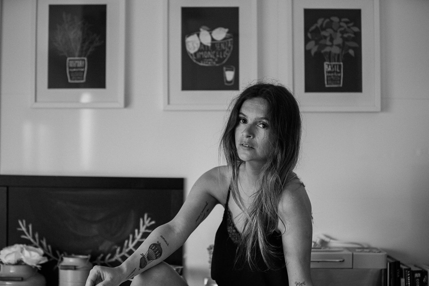 Black and white interior portrait with framed artwork visible on walls.