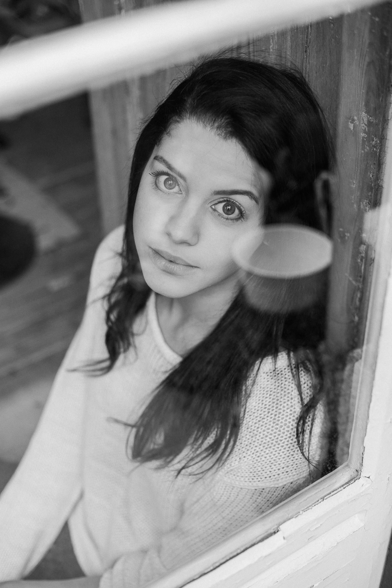 Black and white portrait series showing a person looking through a window with various contemplative expressions.