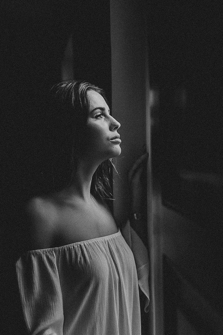 A series of moody black and white portraits showing a woman's profile in dramatic lighting against a dark background.