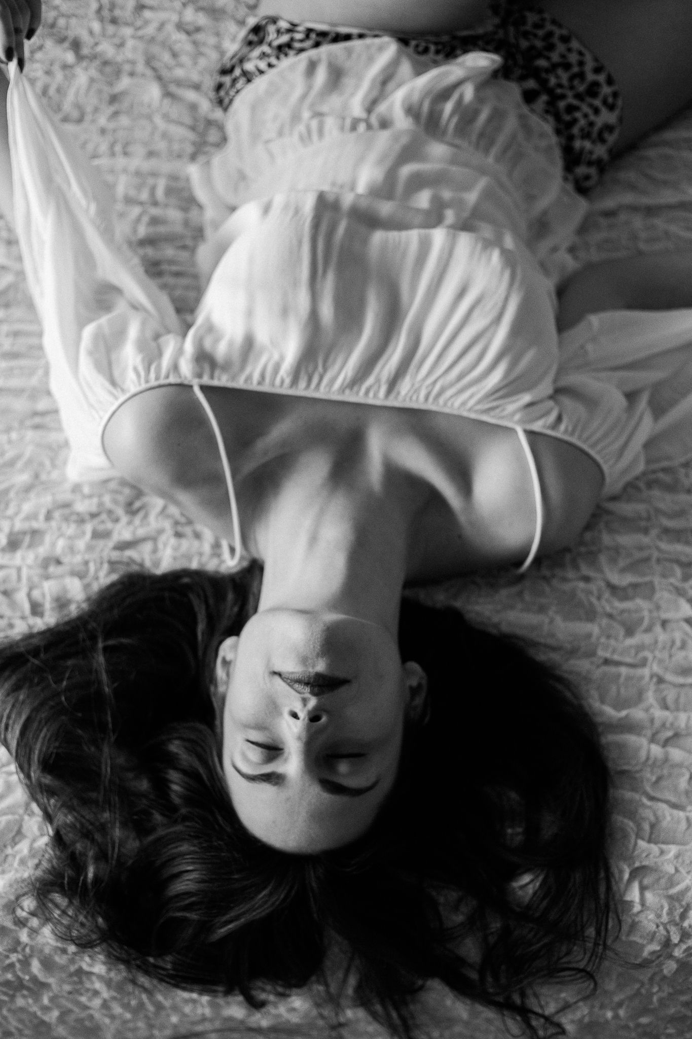 A black and white photo series showing someone lying down with closed eyes and dark hair against white fabric.